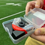 Photo of Daniel Cobian holding a specialized mouthguard that will be used by football players involved in the study. The sensors in the mouthguard will collect data on head impacts.
