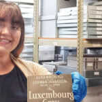 Photo of UWM history alumna Serena Stuettgen holding up an artifact from the archives at the Luxembourg American Cultural Society museum, where she is a curator. (Photo courtesy of Serena Stuettgen)
