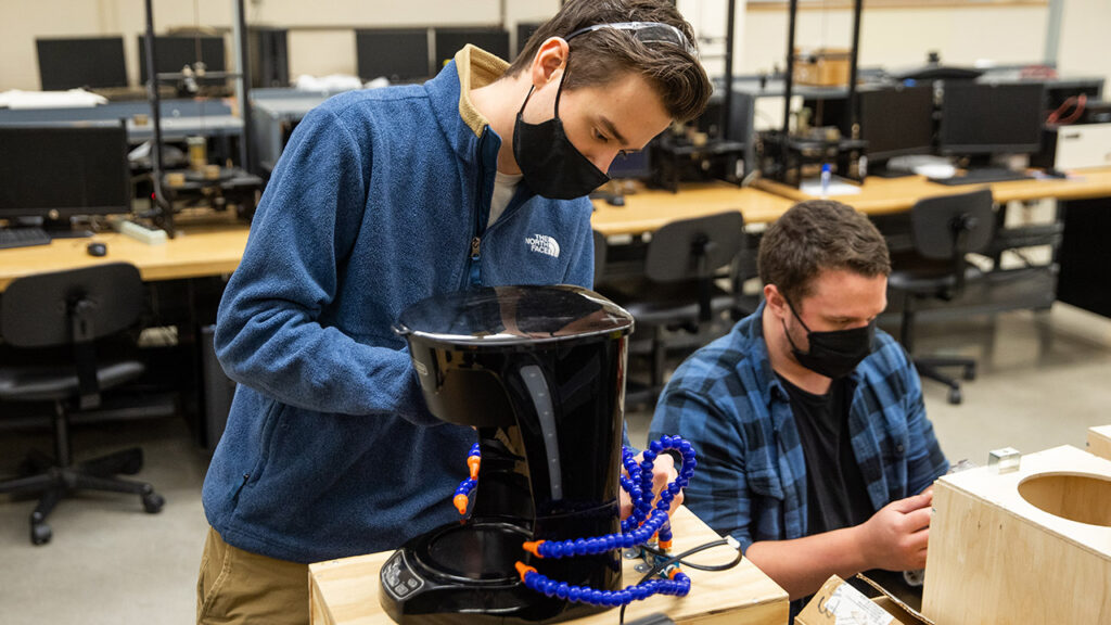 Photo of Michael Zelinsky and Curtis Marschall, members of the Spectrum device cooling team, assembling the final prototypes of their coffee maker cooling solution to test the life cycle.