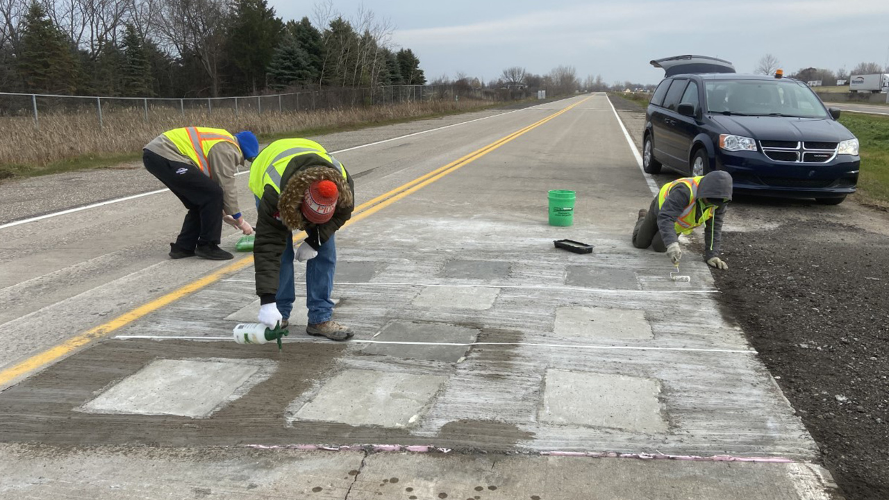 Photo of students applying surface coating on the test track.