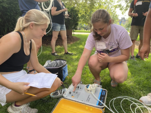 Photo of Emma Johnson and Maddy Knauff measuring groundwater properties at a UW Eau Claire well field.