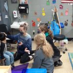 Photo of Carissa Phelps, a CSD second-year graduate student, Hope Wachholz, an undergraduate Spanish interpreter, and Arcadia Childcare Center director Jolynn Bourland working together to complete a young boy’s hearing screening. (Submitted photo)