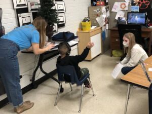 Photo of Abby Joski, a CSD second-year graduate student, and Kayla Kinzler, an undergraduate Spanish interpreter, giving instructions to a young student during his hearing screening in both English and Spanish. (Submitted photo)