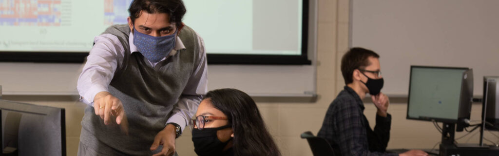 Photo of Dr. Rahul Gomes, assistant professor of computer science, talking with student researcher Avi Devy Mohan about their 2021 research, which was a collaborative project with Mayo Clinic Health System.