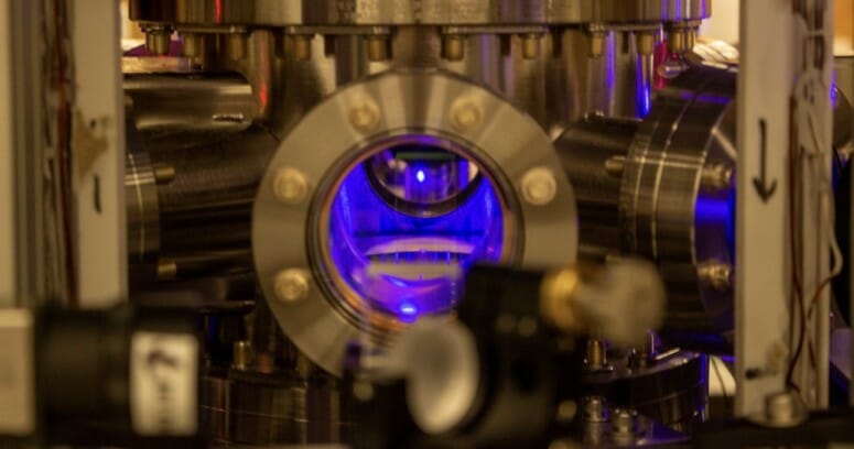 Photo of one of the first steps in creating the optical atomic clocks used in this study, which is to cool strontium atoms to near absolute zero in a vacuum chamber, which makes them appear as a glowing blue ball floating in the chamber. IMAGE PROVIDED BY SHIMON KOLKOWITZ