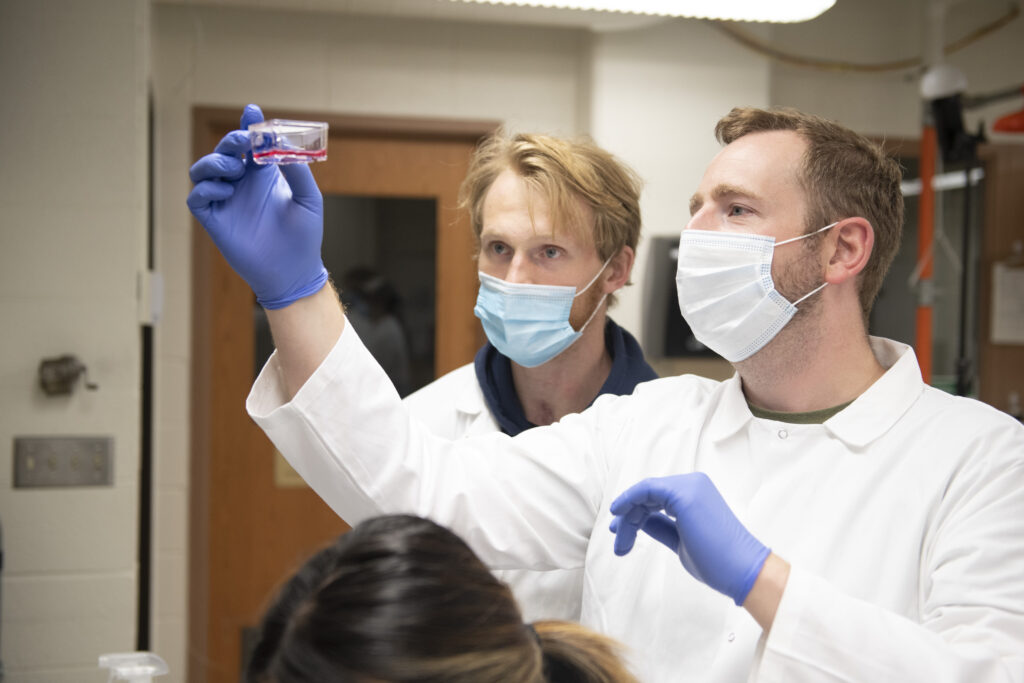 Photo of Zach Caterer (left) who presented the undergraduate student research he is doing with Dr. Michael Walsh (right) during the Research in the Rotunda event in March in Madison. (Photo by Shane Opatz)