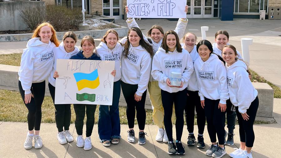 Photo of members of UW-Stout’s gymnastics team promoting their #stuckflipforabuck fundraiser for the people of Ukraine. The challenge started at UW-Stout and has spread nationally. / Kailyn Westbrook