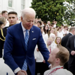 Photo of President Joe Biden, standing, shaking John Boie’s hand at a special ceremony at the Whitewater. (Photo courtesy of the White House)