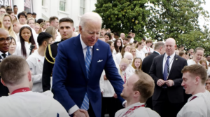 Photo of President Joe Biden, standing, shaking John Boie’s hand at a special ceremony at the Whitewater. (Photo courtesy of the White House)