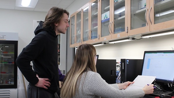 Photo of Cody Korth and McKenzi Fernholz, student researchers in Biology Professor Diane Caporale’s lab at UW-Stevens Point, analyzing 20 years of data on ticks.