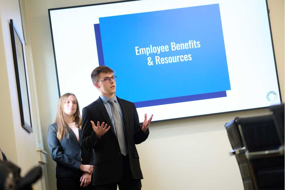 Photo of UW-La Crosse business students Claire Mistele (left) and Jackson Lescamela detailing ways that Kwik Trip can design a work environment for the attraction and retention of new employees. The presentation was part of the Kwik Trip Integrated Core Program at UWL.