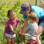 Photo of graduate student Sarah Gifford working in an Eau Claire community garden with children who are part of the CSD’s Kids Communicate Garden Group. While they grow and tend to the garden, the preschoolers are working on a variety of communication skills in a more natural setting. (Photo by Bill Hoepner)