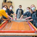 Photo of UW-La Crosse students working on a collaborative art installation with a professional visiting artist