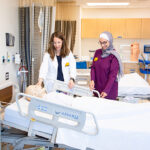 Photo of Melissa Melcher (left), clinical assistant professor, and Bayan Alqam, teaching assistant and PhD nursing student, check a manikin in the Clinical Skills Lab at the new UWM James and Yvonne Ziemer Clinical Simulation Center. (UWM Photo/Elora Hennessey)