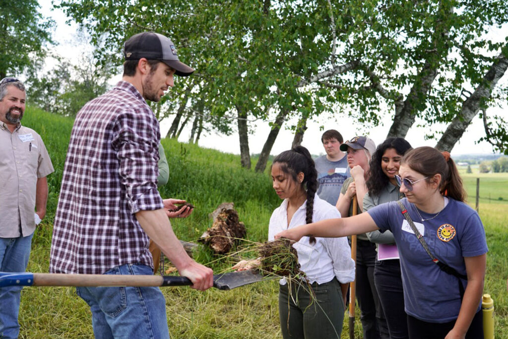 Photo of LAKES 2022 students on the Prestebak farm learn about soil health: (from right) Abby Cullen, Sahi Chundu, Cody Lundquist and Nallely Lepiz-Madrigal. / Chris Ferguson, LAKES co-director