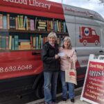 Photo of Mary Mulvaney-Kemp (left) in front of RedLou Library, a mobile library she created to serve Viroqua-area residents. Mulvaney-Kemp, ’82, hopes the library will create more equal access to reading materials in the community.