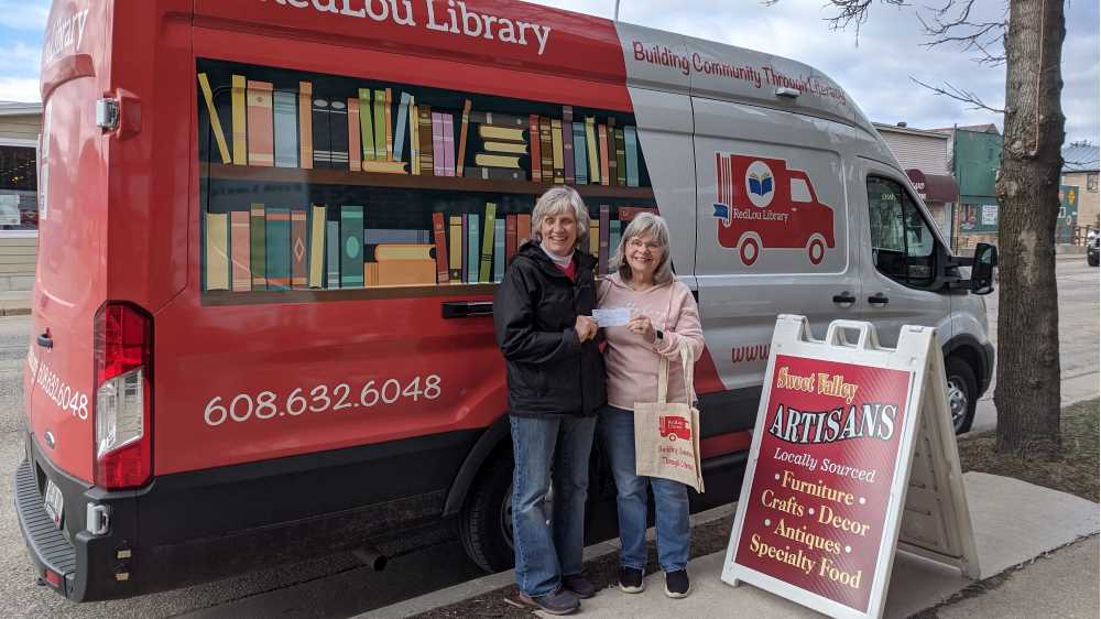 Photo of Mary Mulvaney-Kemp (left) in front of RedLou Library, a mobile library she created to serve Viroqua-area residents. Mulvaney-Kemp, ’82, hopes the library will create more equal access to reading materials in the community.