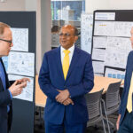 Photo of UWM partners Brian Thompson of the Lubar Entrepreneurship Center (from left) and Lubar College Dean Kaushal Chari discussing training for startups with Matthew Friedel (right), director of the new Business Innovation Incubator that is guiding 10 startups beginning this year. (UWM Photo/Elora Hennessey)