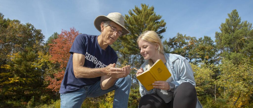 Photo of Dr. Douglas Faulkner, professor of geography, and Grace Bowe, an environmental studies major, examining the banks of western Wisconsin rivers as part of a faculty-undergraduate student research project. Faulkner is receiving a national award for his excellence in mentoring undergraduate research students. Bowe says her professor has helped her discover a passion for studying water and water resources. (Photo by Shane Opatz)