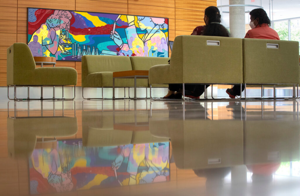 Photo of a mural by artists Alicia Rheal, Sharon Tang and Amy Zaremba now hanging in the Town Center of the Discovery Building. The Wisconsin Alumni Research Foundation commissioned the work, titled “Landscape of Discovery.” MICHAEL P. KING