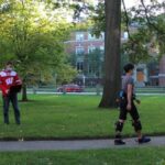 Photo of a study participant wearing the exosuit and tensiometer while walking outside. PHOTO BY HARVARD BIODESIGN LAB