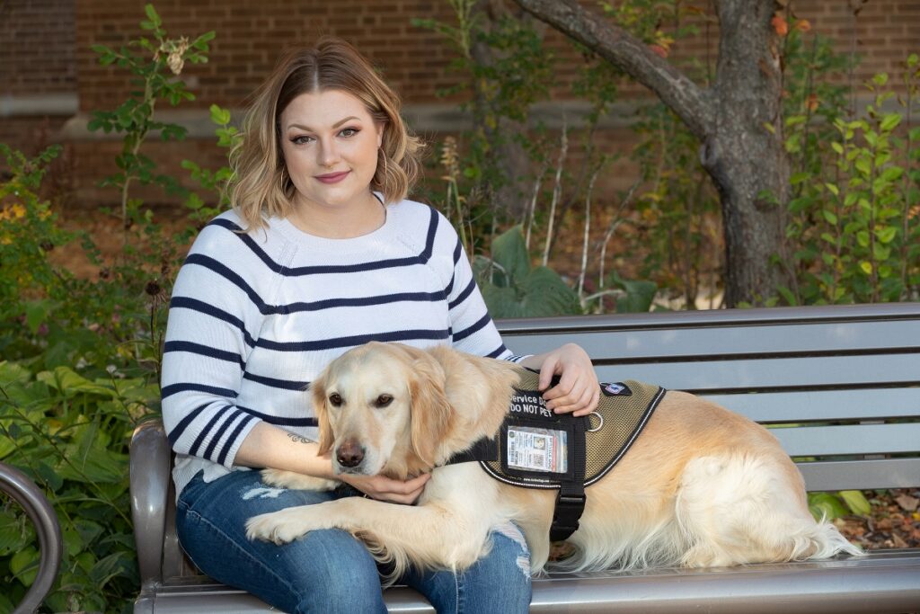 Photo of Randi Miranda, a U.S. Navy veteran and senior dietetics major, shown with her service dog, Abbey. They took part in a Veterans Day ceremony on Nov. 11 at UWSP.
