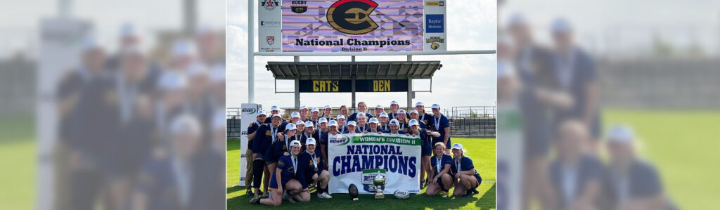 Photo of the UW-Eau Claire women’s rugby club team proudly displays the Division II National Champions pennant. (UW-Eau Claire)
