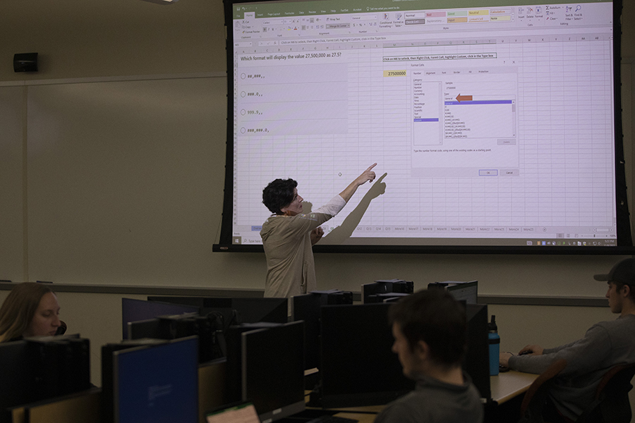 Photo of advisor Linda Amann, lecturer of information technology and supply chain management, pointing out a feature of Excel during a practice session with the UW-Whitewater Excelerators team. (Photo by Craig Schreiner/UW-Whitewater)