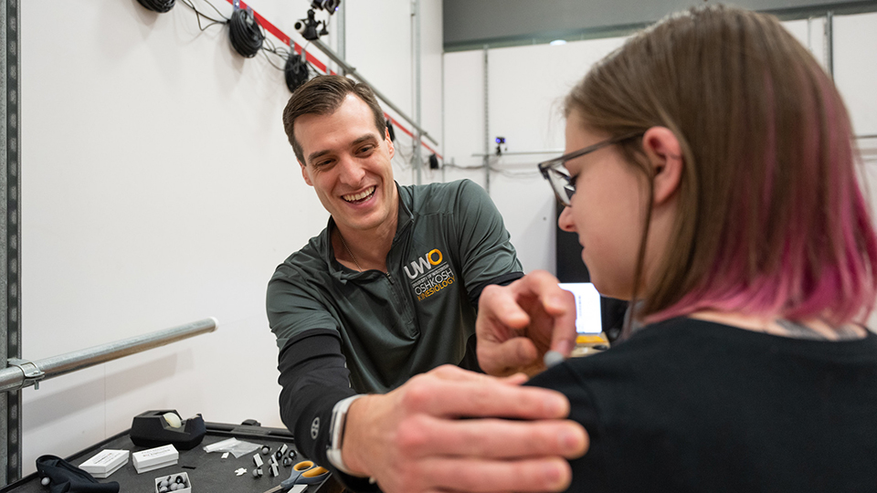 Photo of Kevin Biese, assistant kinesiology professor and graduate student Abby Godejohn ’22, preparing to use motion capture markers in one of the rooms that make up the new Sport Performance and Injury Research Lab at UW Oshkosh. 