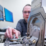 Photo of Sam Alvarado, associate professor of inorganic chemistry at UWRF, training on the university’s new Hitachi scanning electron microscope (SEM) in Centennial Science Hall.