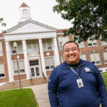 Photo of School Counselor See ViXai Thao poses in front of Washington Middle School in Manitowoc. UW-Green Bay, Sue Pischke University Photographer