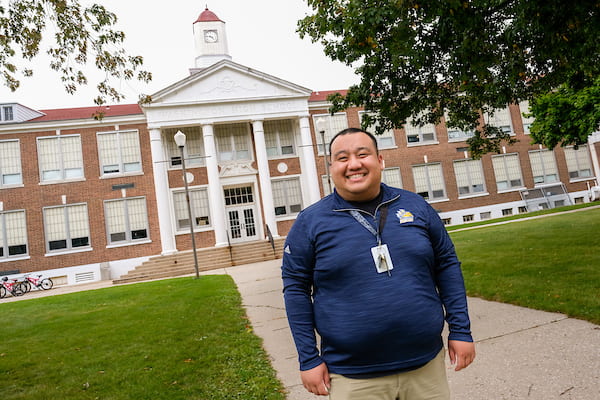 Photo of School Counselor See ViXai Thao poses in front of Washington Middle School in Manitowoc. UW-Green Bay, Sue Pischke University Photographer