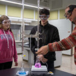 Photo of Dr. Stephen Swallen, professor of chemistry, working with students.