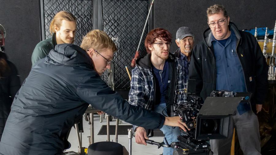 Photo of (from left) students Nicos Wiard, Robinson Ohman, Evan Rosenberg, staff member Ed Jakober and instructor Colin O’Neill examining a Fisher dolly at Cinequipt. / UW-Stout