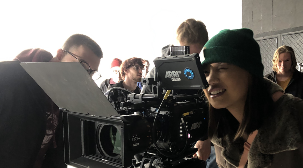 Photo of UW-Stout student Delaney Hoffman looking through a viewfinder at Cinequipt on an Arri Alexa camera, used for high-end motion imaging.