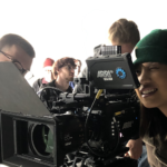 Photo of UW-Stout student Delaney Hoffman looking through a viewfinder at Cinequipt on an Arri Alexa camera, used for high-end motion imaging.