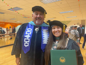 Photo of Dr. King holding her diploma and posing with fellow student Dr. Artley Skenandore at graduation. (Photo courtesy of Dr. King)