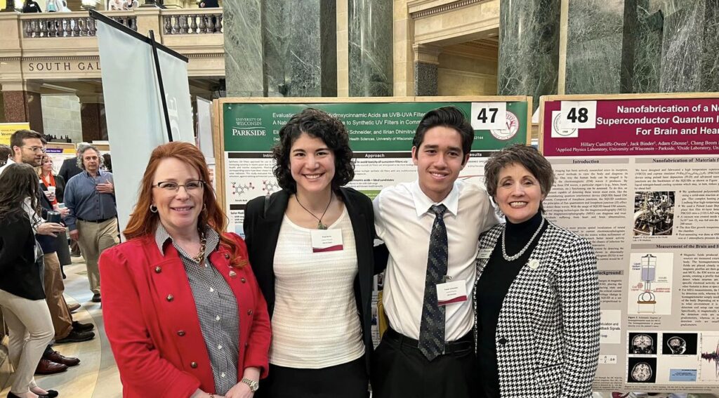 Photo of UW-Parkside Chancellor Debbie Ford (far right) pictured at the March 8, 2023, Research in the Rotunda event with (from left) Representative Amanda Nedweski (R-Pleasant Prairie) and student researchers Elise Zevitz and Trever Schneider, who investigated the UV-blocking potential of naturally occurring, plant-based compounds in sunscreens.
