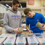 Photo of Dylan Notsch and Will Straka (left to right) studying the effects of anti-icing on concrete.