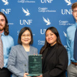 Photo of the team of University of Wisconsin-Superior transportation and logistics management and supply chain management students, which included Matt Thompson, Laura Kumimatsu and Kallahan Kappes, and coached by Mei Cao (second from left), who earned first place in the annual UNF Logistics & Supply Chain Management Case Competition. (Photo courtesy of University of Wisconsin-Superior)