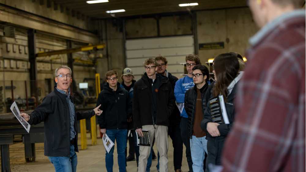 Photo of Paul Bagniefski, far left, president of Mid-City Steel, leading UW-La Crosse accountancy students on a tour of the company's manufacturing facilities. This spring, students are gaining real-world accounting experience through a partnership with Mid-City Steel — part of UWL's Community Engaged Learning program.