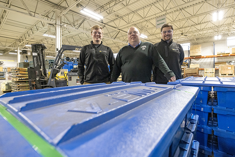 Photo of Easton Dobson (left) and Colin Haagensen flanking Steve Coolidge, general manager of AAA Sales & Engineering on the floor of the company’s Oak Creek plant. Dobson, Haagensen and another student, Ryan O’Day, worked on a project that benefited the company and gave the students real-world experience. (UWM Photo/Troye Fox)