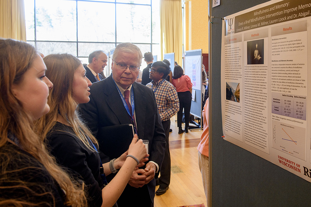 Photo of UW System President Jay Rothman conversing with UW-River Falls students Lauren Loock, center, and Linnea Milner Thursday as they presented their work during the National Conference of Undergraduate Research at UW-Eau Claire. Bill Hoepner photo.