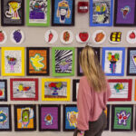 Photo of Hollyn Peterson, an art and art education major from Waukesha, looking at art she helped students create during her student teaching time at Meadowbrook Elementary School in Waukesha.