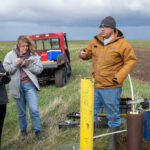 Photo of students learning about the groundwater sampling network at Pioneer Farm and receive a demonstration on how to sample water from wells.