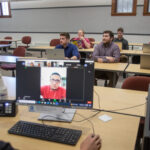 Photo of student teams, who were paired with clients in Honduras, giving them the unique opportunity to help under-resourced entrepreneurs, while navigating a different language and culture. Pictured in back row: Evan Benkovich, Bryant Keeffer, and Nick Schaal; middle row: Darian Wright, John Biernat, and Alex Schulz; and in front at the desk: Joshua Ellsoos. (Photo credit: UW-Platteville)