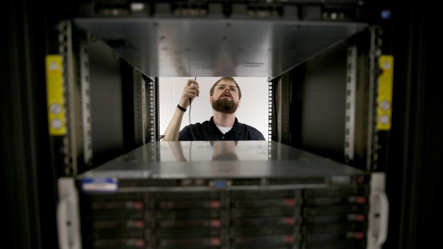 Photo of a student checking servers while working in UW-Stout’s cybersecurity labs. / UW-Stout