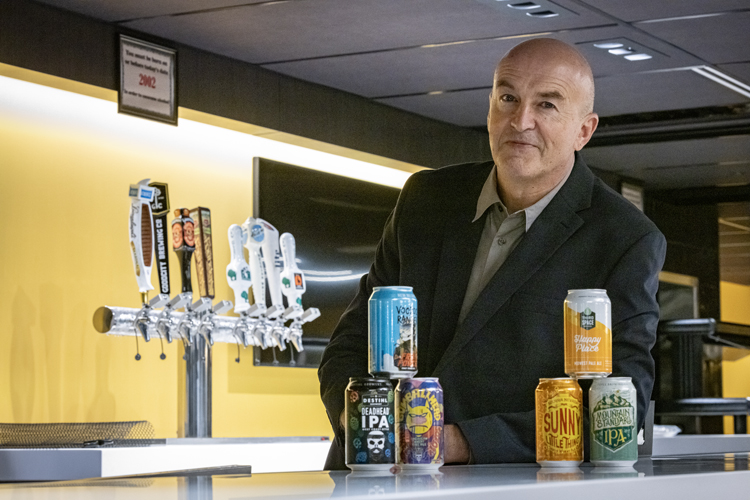 Photo of Stanislav Dobrev, professor of organizations and strategic management in the UWM Lubar College of Business, showing some examples of craft beer names. Positive names include Sunny Little Thing and Happy Place. More negative or quirky names are Voodoo Ranger and Deadhead. The latter duo had better online reviews, according to Dobrev's study, because they were perceived as more authentic. (UWM Photo/Troye Fox)