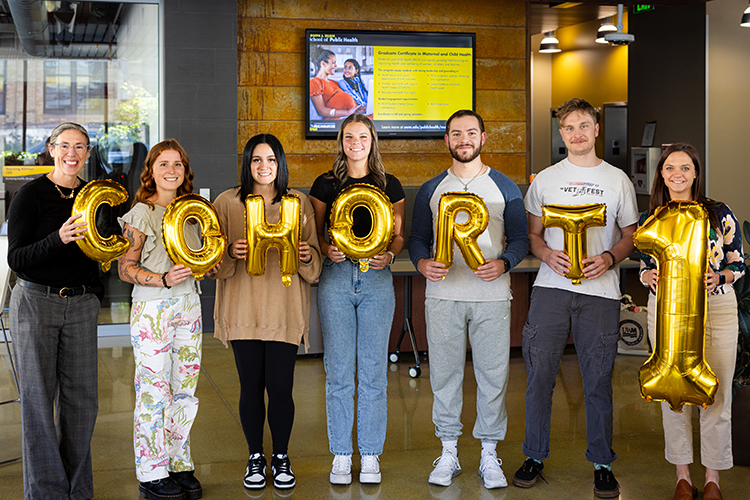Photo of Lori Klos (left), associate professor, and Stephanie Send, clinical assistant professor (right), celebrating with the first cohort of students in the new MPH Nutrition and Dietetics program at UWM: Delaney Ortiz (from left of Klos), Cianna Colon, Erica Brincka, David Jakubek and Zachary Long. Not pictured is Lora Taylor de Oliveira, clinical associate professor. (UWM Photo/ Elora Hennessey)