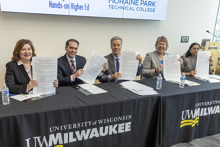 Photo of UWM Chancellor Mark Mone (center) and the leaders of four regional technical colleges, who signed an agreement Tuesday to smooth the path for tech school graduates to attend the university. From left are MATC President Vicki Martin, WCTC President Richard Barnhouse, Moraine Park President Bonnie Baerwald and Gateway President Ritu Raju. (UWM Photo/Troye Fox)